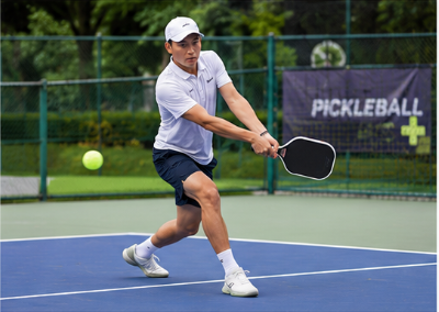 Người chơi thực hiện cú Backhand trên sân Pickleball ngoài trời.